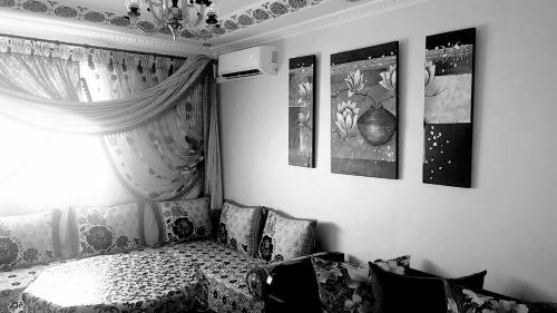 - une chambre avec un lit et des photos sur le mur dans l'établissement Jawharat Tetouan, à Souani
