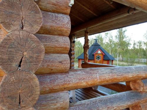 una cabaña de madera con una casa de aves en la ventana en Johansens hytteutleie en Tana