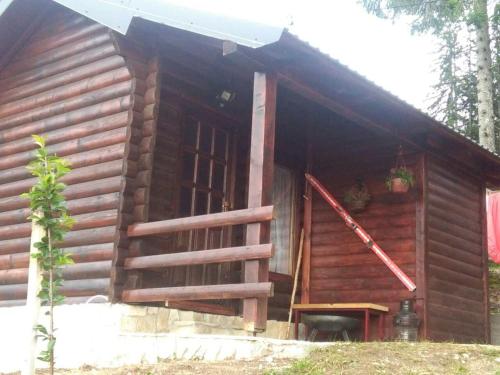 a log cabin with an open door and a porch at Cozy Cabin in Žabljak
