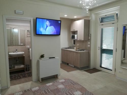 a bathroom with a tv hanging on the wall at Guest House B&B Via Marina in Reggio Calabria