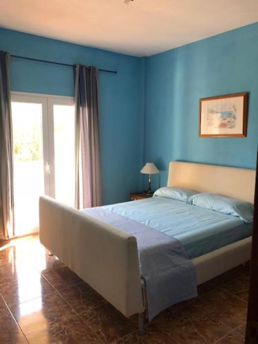 ソン・セッラ・デ・マリーナにあるChalet Son Serraの青い壁のベッドルーム1室、ベッド1台が備わります。