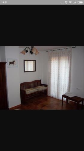 sala de estar con sofá y ventana en El Corral Del Tio Emilio, en Cuenca