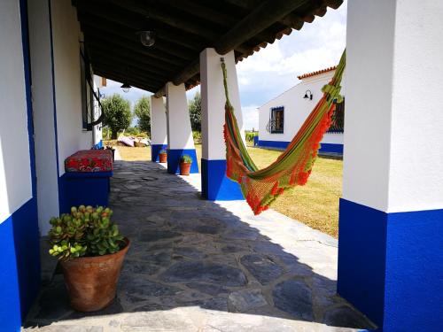 a hammock hanging from a porch of a house at Monte dos Velhos in Reguengos de Monsaraz