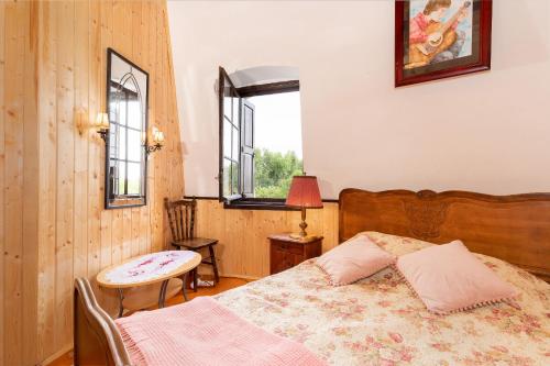 a bedroom with a bed and a table and a window at Windmill vacation home in Ledzin near Baltic Sea in Niechorze