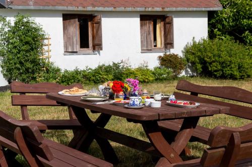 a wooden picnic table with food and flowers on it at Windmill vacation home in Ledzin near Baltic Sea in Niechorze