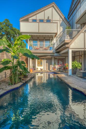 a swimming pool in front of a house at Houston Towers Inn, Adults-Only, Downtown, Med Ctr, NRG in Houston