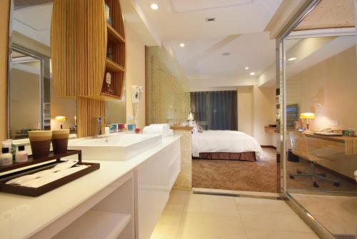 La salle de bains est pourvue d'un lavabo et d'un lit dans la chambre. dans l'établissement Homey House, à Taipei
