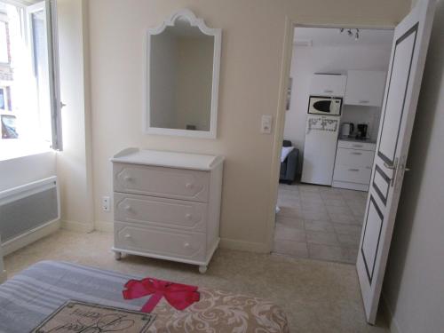 Cette chambre dispose d'une commode avec un miroir et d'une cuisine. dans l'établissement maisonnette avec jardin proche du Mont Saint Michel, à Pontorson