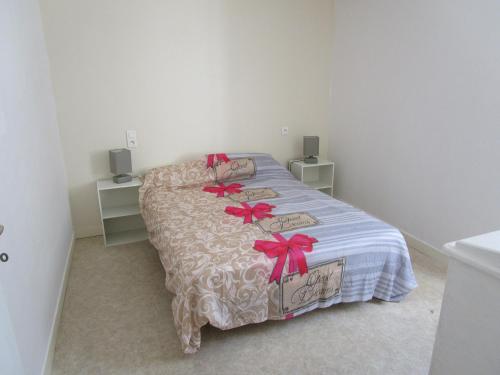 a bedroom with a bed with red bows on it at maisonnette avec jardin proche du Mont Saint Michel in Pontorson