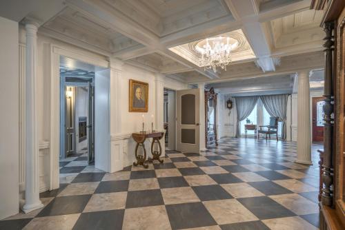 a large hallway with a checkerboard floor and a chandelier at Houston Towers Inn, Adults-Only, Downtown, Med Ctr, NRG in Houston