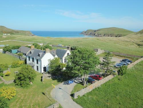 an aerial view of a house on a hill next to the ocean at Farr Bay Inn in Bettyhill