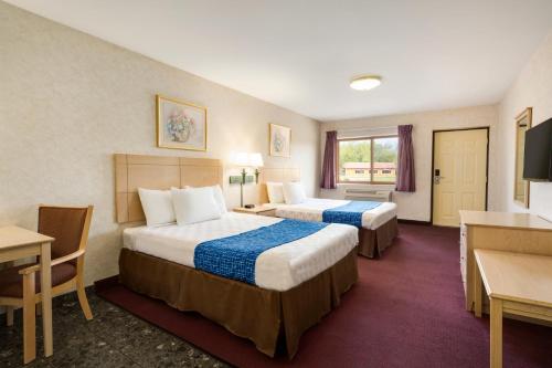 מיטה או מיטות בחדר ב-Travelodge by Wyndham Niagara Falls - New York