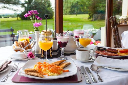 a table with a plate of breakfast foods and drinks at Langdon Farm Guest House in Saundersfoot