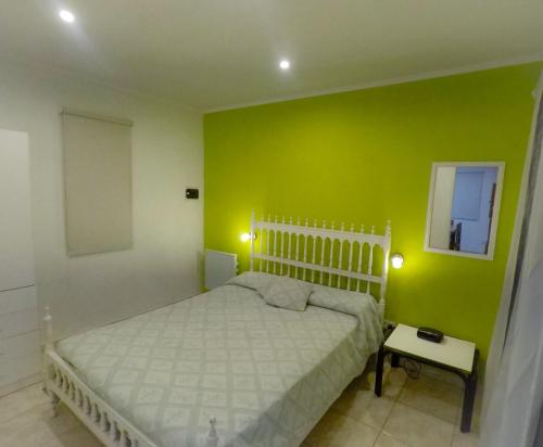 1 dormitorio con cama y pared verde en Departamento Monte Hermoso en Monte Hermoso
