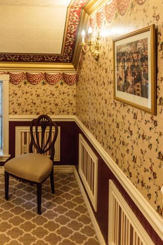 a chair sitting in a room with wallpaper at Frisco Lodge in Frisco