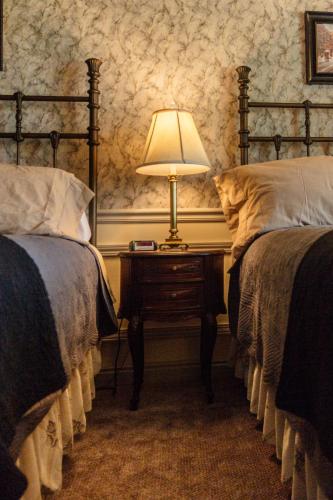a bedroom with two beds and a table with a lamp at Frisco Lodge in Frisco