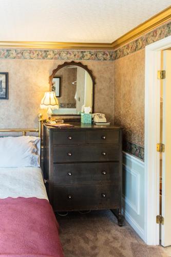 a bedroom with a bed and a dresser with a mirror at Frisco Lodge in Frisco