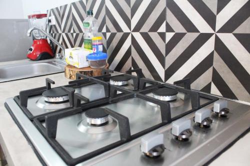 a stove top in a kitchen with a geometric wall at Gaia Studios in Cancún