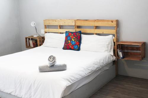a bedroom with a white bed with a wooden headboard at Gaia Studios in Cancún