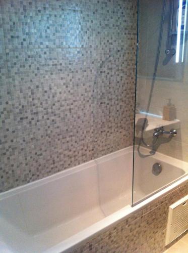 een badkamer met een douche en een glazen deur bij Appartement Cosy - Corniche plage Mohammedia in Mohammedia
