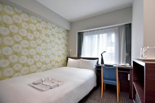 東京的住宿－新宿普乐美雅凯宾酒店 ，配有一张床和一张书桌的酒店客房
