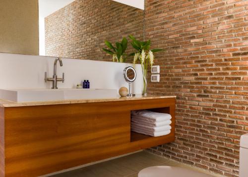 a bathroom with a sink and a brick wall at Let's Sea Hua Hin Al Fresco Resort in Hua Hin