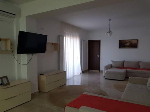 a living room with a couch and a flat screen tv at Apartament Raldar Mamaia Nord in Mamaia Nord