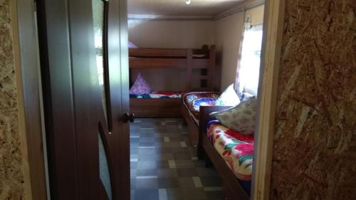 a small room with two bunk beds and a door at Ala-Kul guesthouse in Altyn-Arashan in Karakol