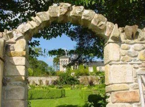 a stone archway with a house in the background at Loch Ness Country House Hotel in Inverness