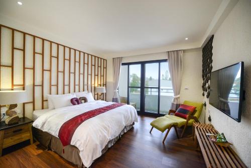 小琉球的住宿－泰美風情旅店，一间卧室设有一张大床和一个大窗户