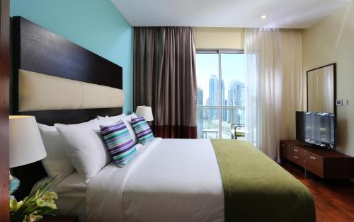 a hotel room with a large bed and a television at Ramada by Wyndham Downtown Dubai in Dubai