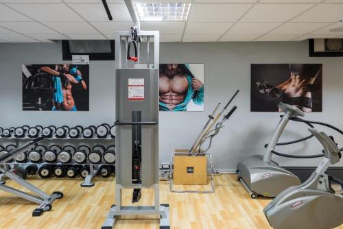 a gym with cardio machines and posters on the wall at Hotel Martini in Verona