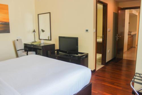 a hotel room with a bed and a television at Ramada by Wyndham Downtown Dubai in Dubai