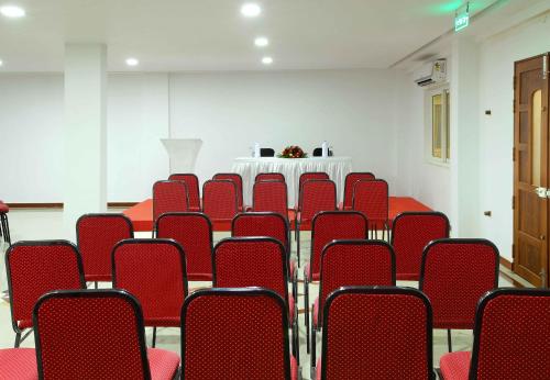 an empty room with red chairs and a table at Sr Palaceinn in Kolattupuzha
