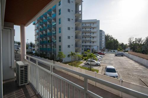 a balcony of a building with cars parked in a parking lot at Mosaic Condminum A24m by malai in Mae Pim