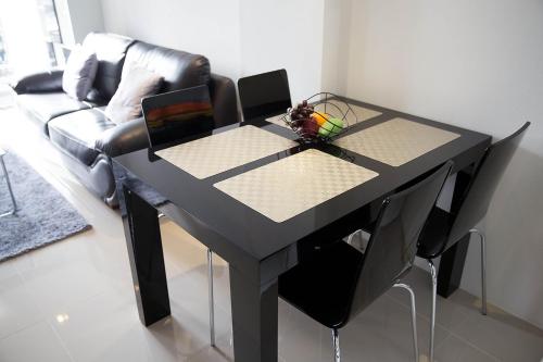 a black table in a living room with a couch at Mosaic Condminum A24m by malai in Mae Pim