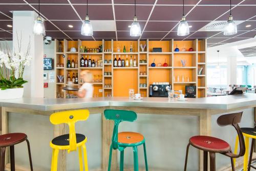 a bar with colorful stools in a store at Ibis Styles Sallanches Pays du Mont-Blanc in Sallanches