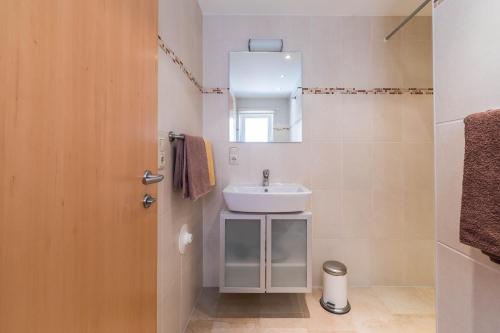 ein Bad mit einem Waschbecken und einem Spiegel in der Unterkunft Ferienwohnung Arndt in Fulpmes