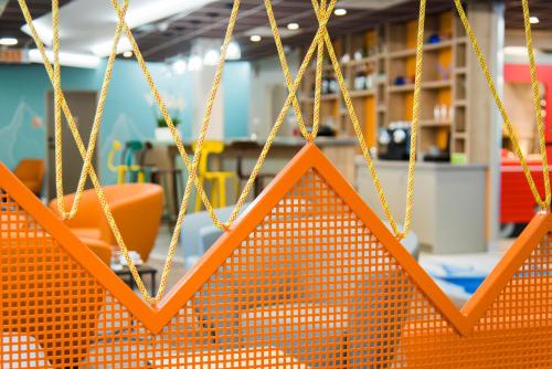 an orange sign is hanging from a chain at Ibis Styles Sallanches Pays du Mont-Blanc in Sallanches