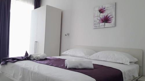 a bedroom with a large bed with white sheets and pillows at Apartmani Marija Mljet in Sobra