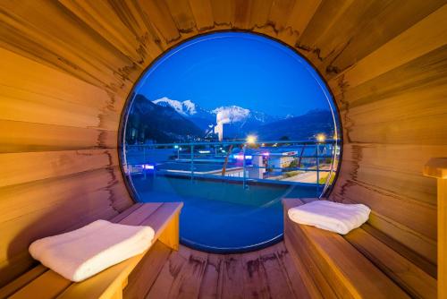 a round window in a wooden sauna with a pool at Ibis Styles Sallanches Pays du Mont-Blanc in Sallanches