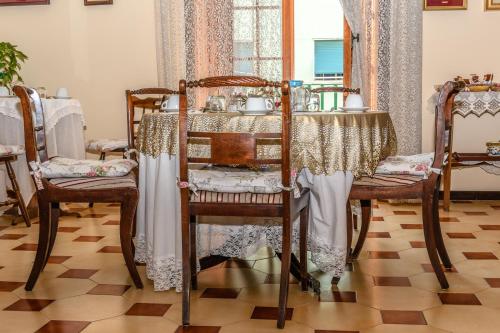 een tafel met twee stoelen en een tafel met een tafelkleed bij B&B Il Nido in Portici