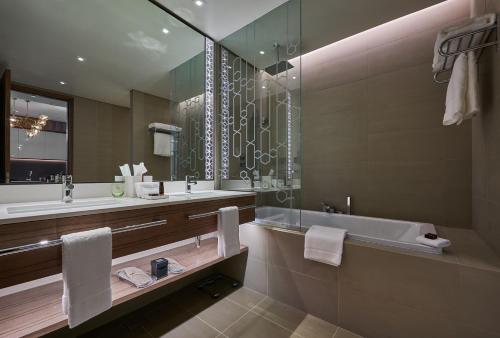 فندق ميسك الموج في مسقط: حمام مع حوض ومغسلة وحوض استحمام