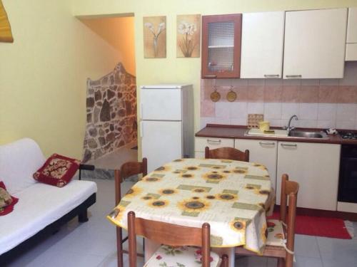a kitchen with a table and chairs and a kitchen with a sink at Casa Olbia 2 in Olbia