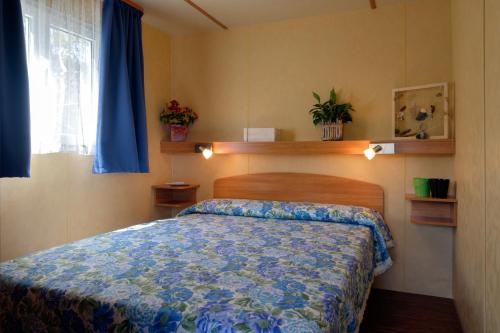 um quarto com uma cama com um edredão azul em Ca' Berton Village em Cavallino-Treporti