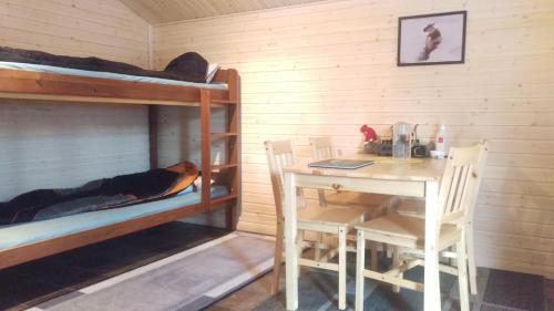 a room with a table and bunk beds at JVT Cabins in Kiruna