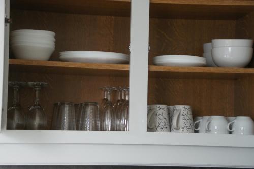 a cabinet filled with dishes and cups and bowls at La Goélette in Bazincourt-sur-Saulx