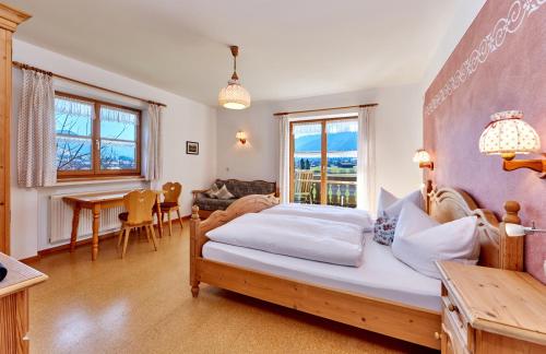 ウンターアンマーガウにあるGästehaus-Bauernhof Buchwieserのベッドルーム1室(ベッド1台付)、リビングルームが備わります。
