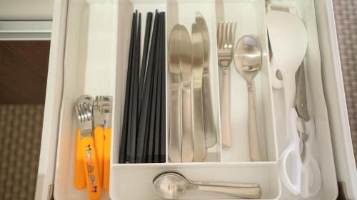 a white drawer filled with utensils and silverware at Hotel From Okinawa in Naha