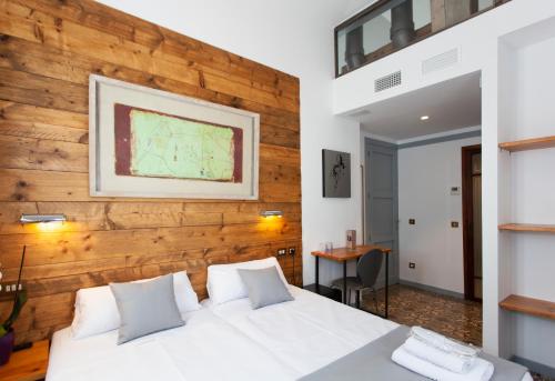 - une chambre avec un lit blanc et un mur en bois dans l'établissement Gran H La Marina, à Altea